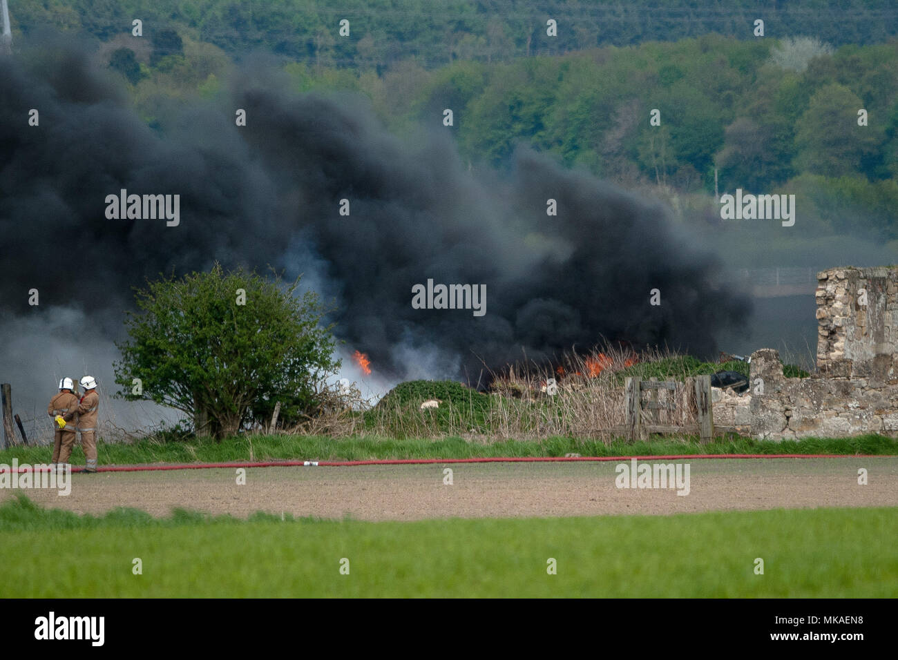 Airth, Falkik, UK. 7 mai, 2018. 2 pompiers à la sur-pupilles vers le brasier. Les pompiers ont été appelé pour faire face à un incendie dans l'Airth, Falkirk. 3 camions et 5 à 8 pompiers présents sur scène. La police a la route jusqu'à qu'elle est fermée. Crédit : Stewart Kirby/SOPA Images/ZUMA/Alamy Fil Live News Banque D'Images