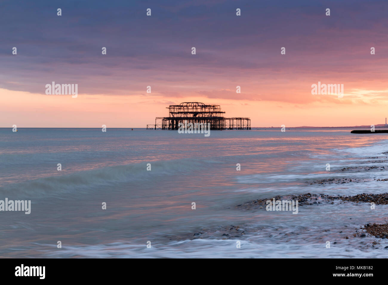 Couleurs rose et orange sunset et jetée ouest de la plage de Brighton, East Sussex, UK. Banque D'Images