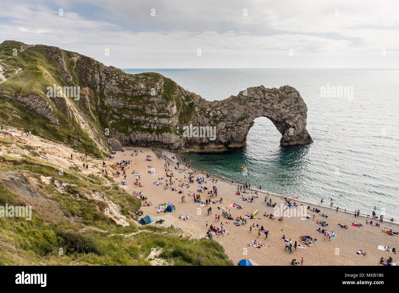 Dorset, Angleterre, Royaume-Uni - 13 août 2016 : Les vacanciers baignoire à Durdle Door calcaire naturel arch, un honeypot touristique sur la côte jurassique monde Herita Banque D'Images