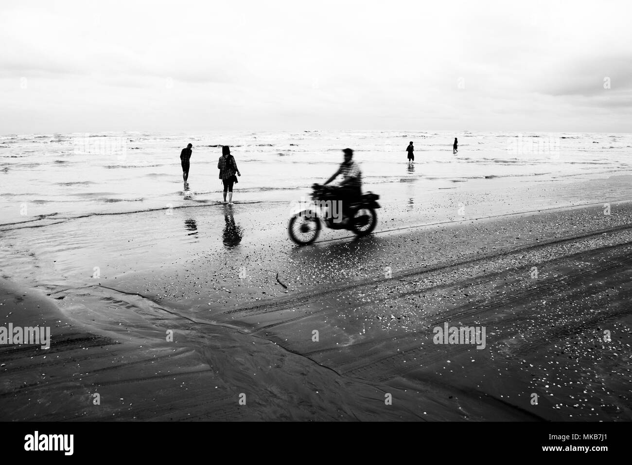 Mesdames avec voile, marcher dans la côte de la mer Caspienne en Iran et une moto rider est passant par Banque D'Images