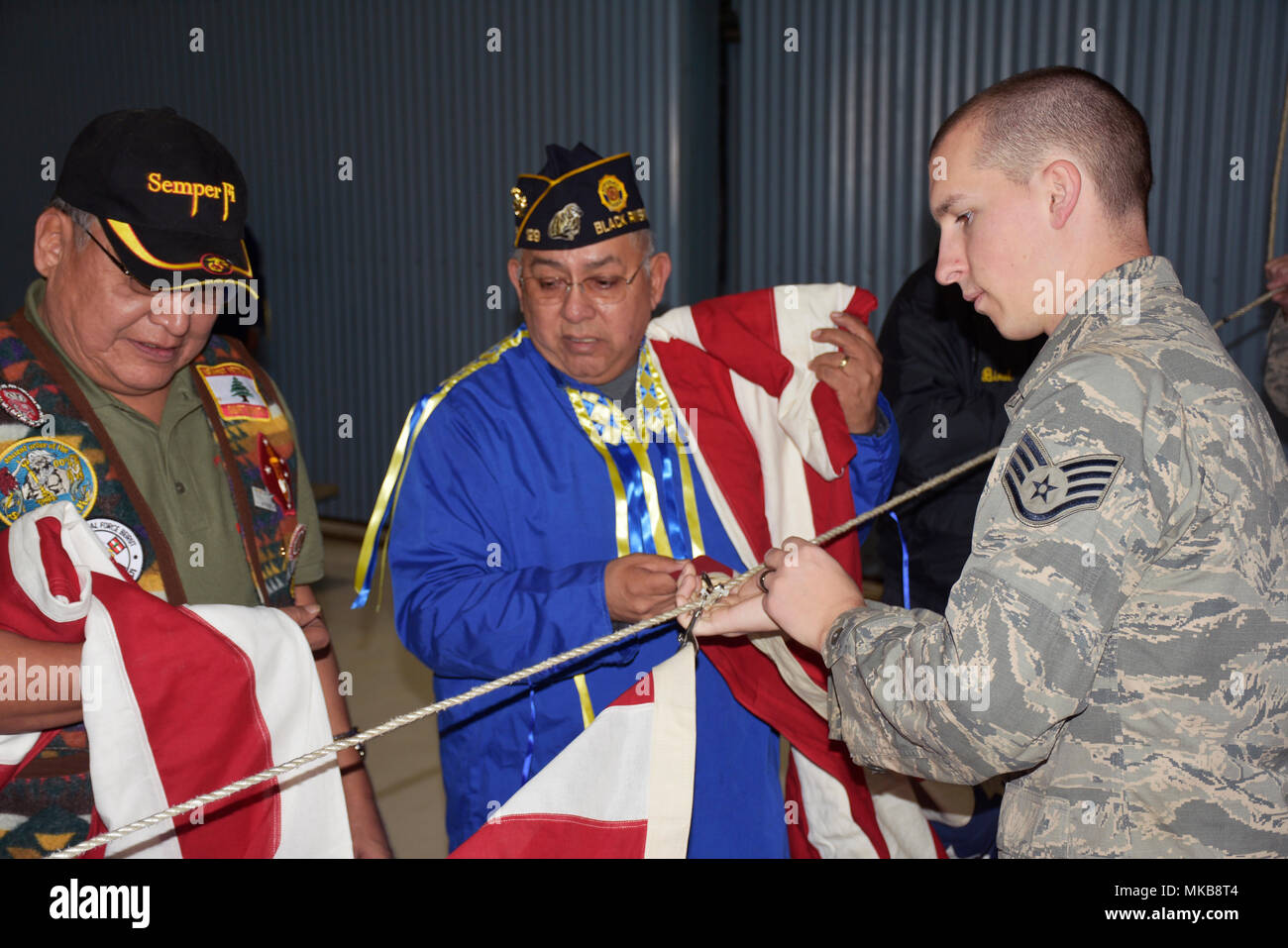 Le s.. Cody Mara, Volk Field la préparation au combat au Centre, aide à la famille de fixation des drapeaux pour une ligne d'honneur pour les anciens combattants américains honorés lors de la 40e édition annuelle de descendants de Flèche Rouge Pow-Wow Journée des anciens combattants. Les descendants de Flèche Rouge ont célébré leur 40e Journée des anciens combattants 11 novembre au Pow-Wow Volk Field en l'honneur de 28 Autochtones américains qui ont servi dans la Garde nationale du Wisconsin's Company D, 128e d'infanterie, 32e Division au cours de la Première Guerre mondiale. La Garde nationale du Wisconsin photo : Capt Brian Faltinson Banque D'Images