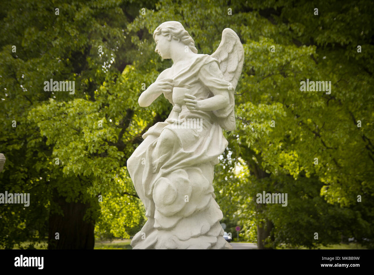 Statue ange vert dans le jardin avec arbres en arrière-plan Banque D'Images