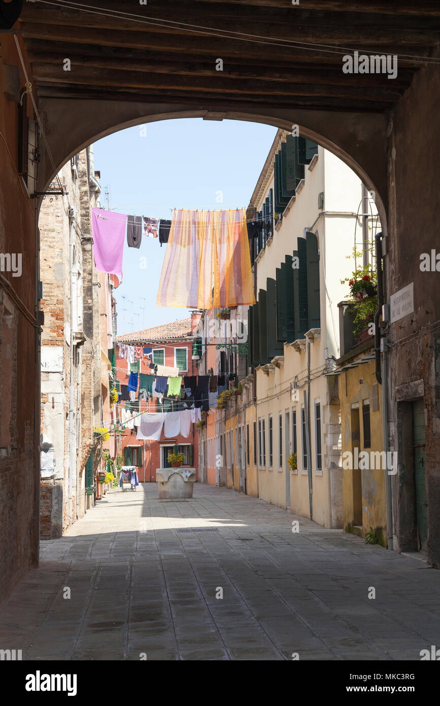 Voir à travers un passage couvert (sotoportego voûté) de lave-pendaison sur les lignes de lessive sur , Castello, Venise, Italie Banque D'Images