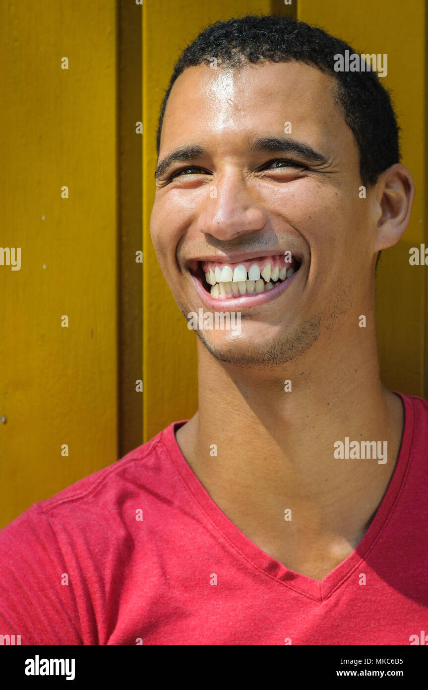 Portrait d'un homme afro-américain avec un grand sourire sur un mur jaune Banque D'Images