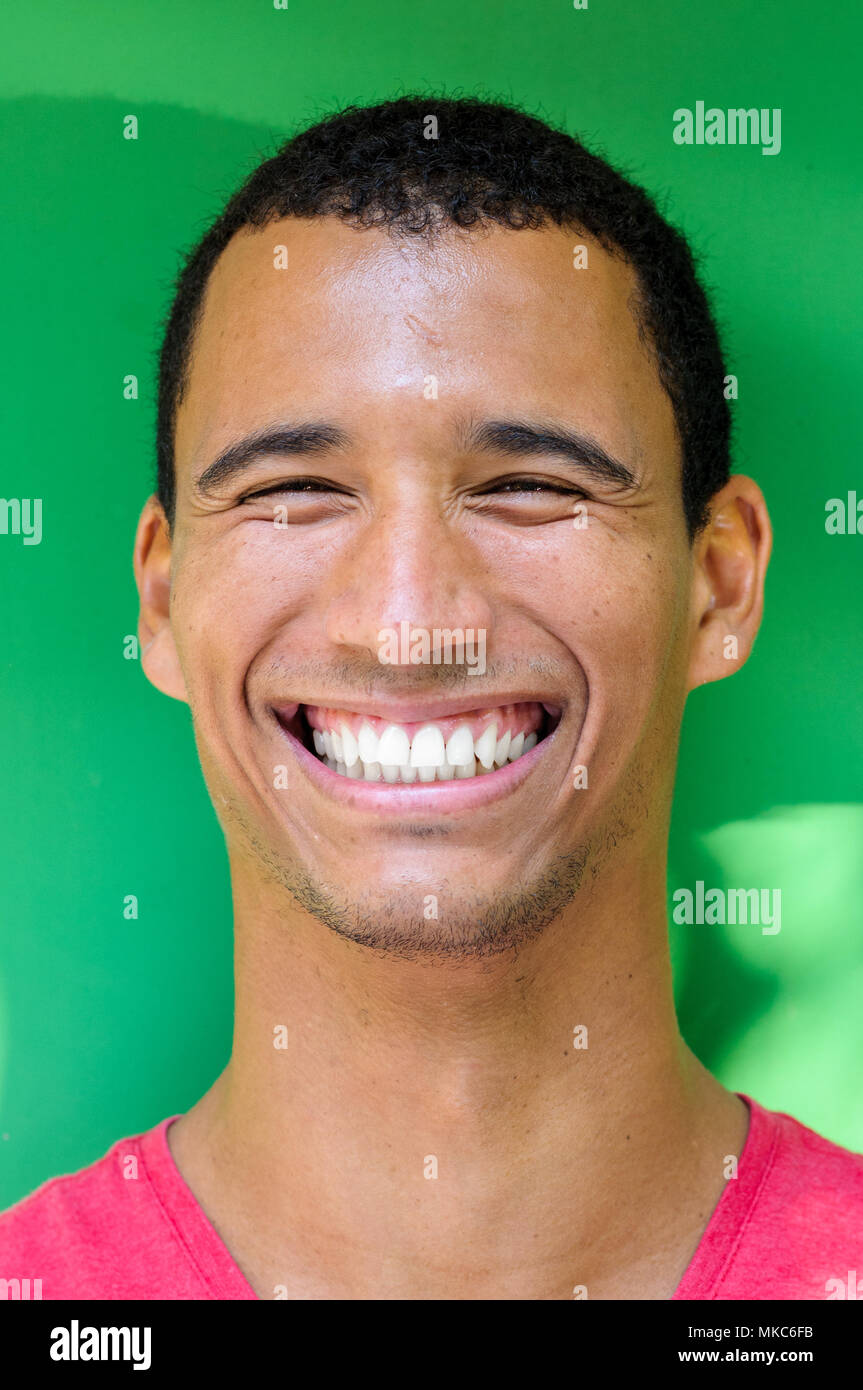 Portrait d'un homme afro-américain avec un grand sourire sur un mur vert Banque D'Images