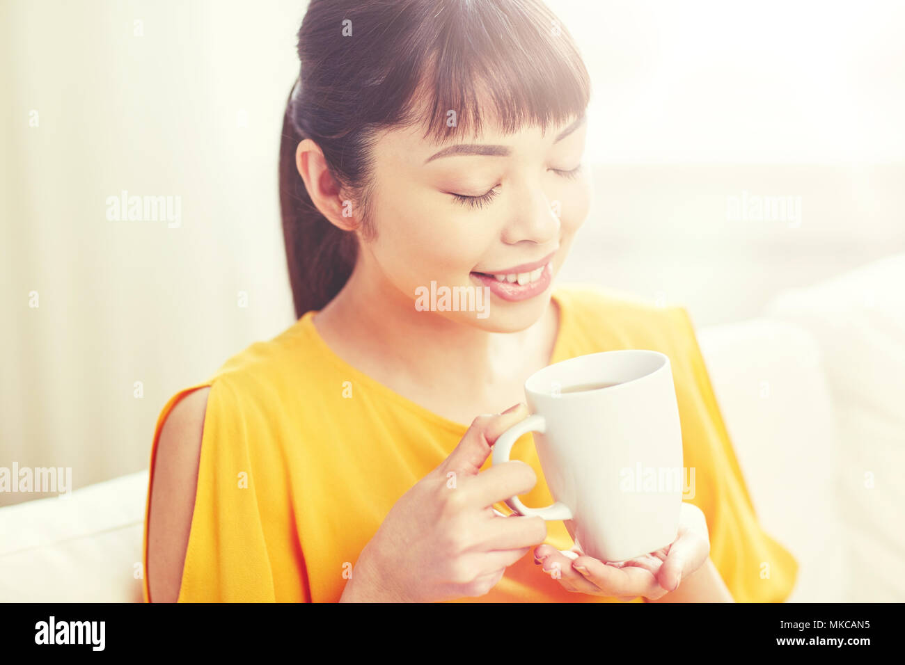 Happy asian woman à partir de la tasse de thé Banque D'Images