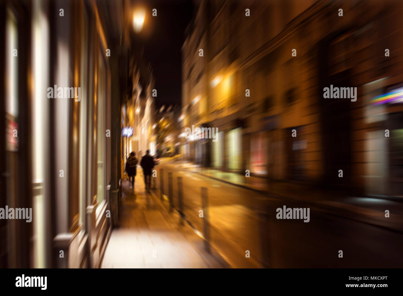 Motion floue image de personnes marchant sur la rue la nuit à Paris. Banque D'Images