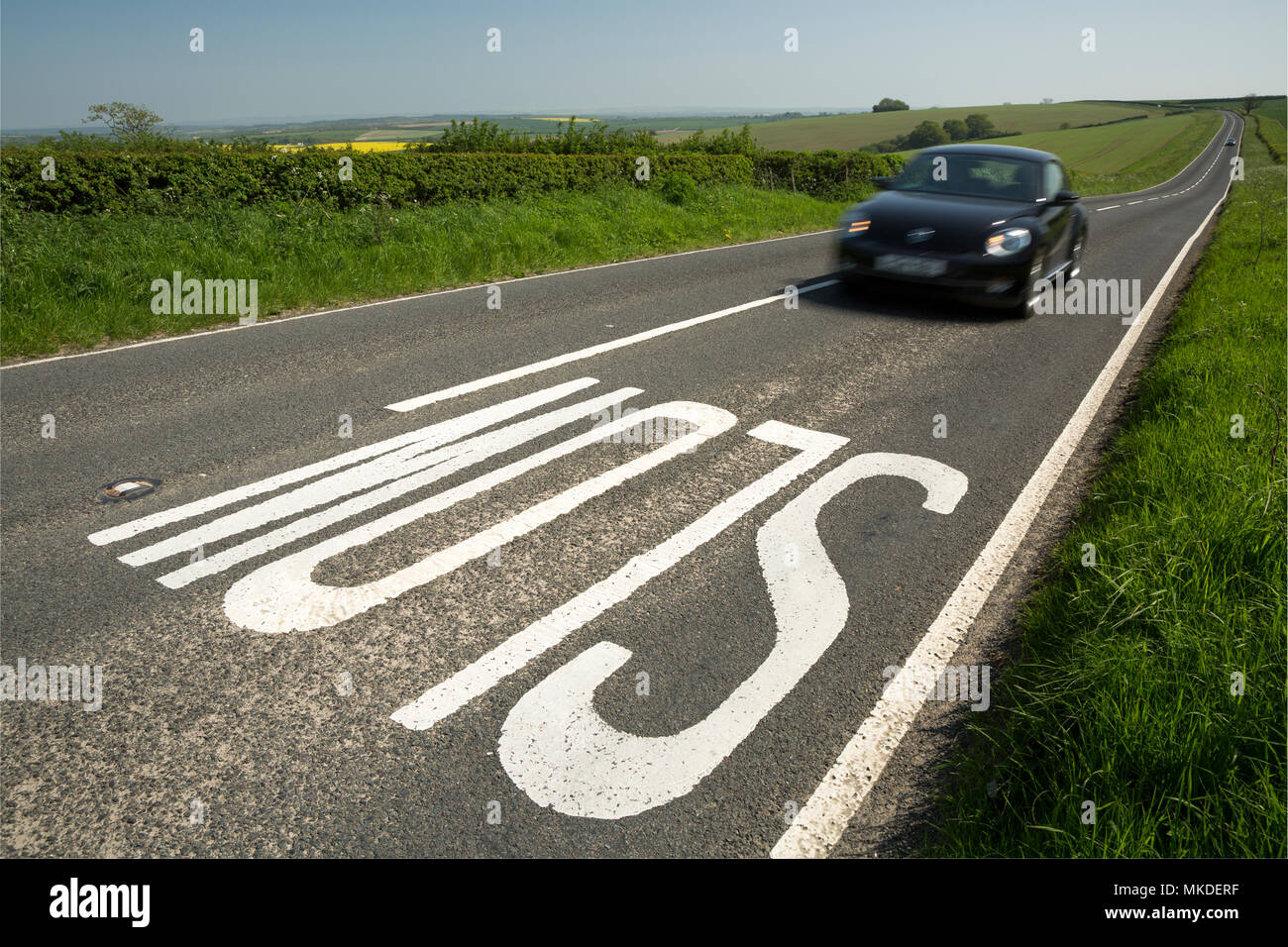Un lent signe sur le front d'une colline sur une route menant à la distance à Dorchester, dans le Dorset England UK Banque D'Images