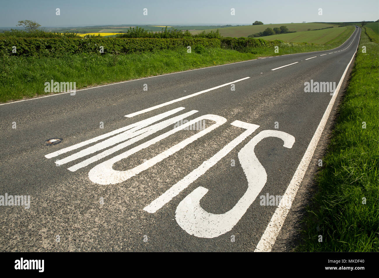 Un lent signe sur le front d'une colline sur une route à travers la campagne du Dorset qui mène dans la distance à Dorchester, dans le Dorset England UK. Le 7 mai 2018 Banque D'Images
