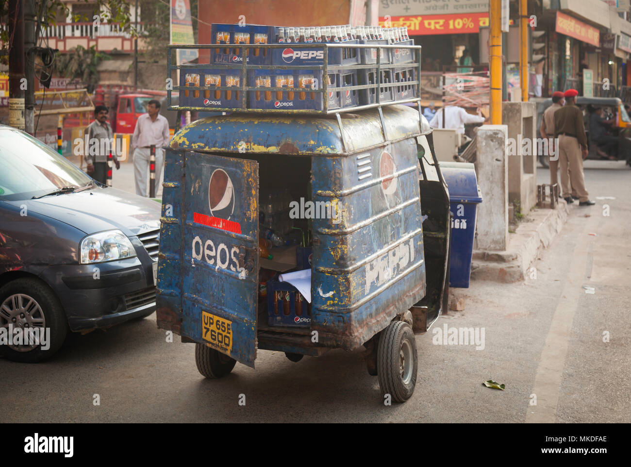La rouille, la fourgonnette de livraison battues boucles sous le poids de toutes ces bouteilles qui doivent être livrés à l'étals de rue à Varanasi. Banque D'Images