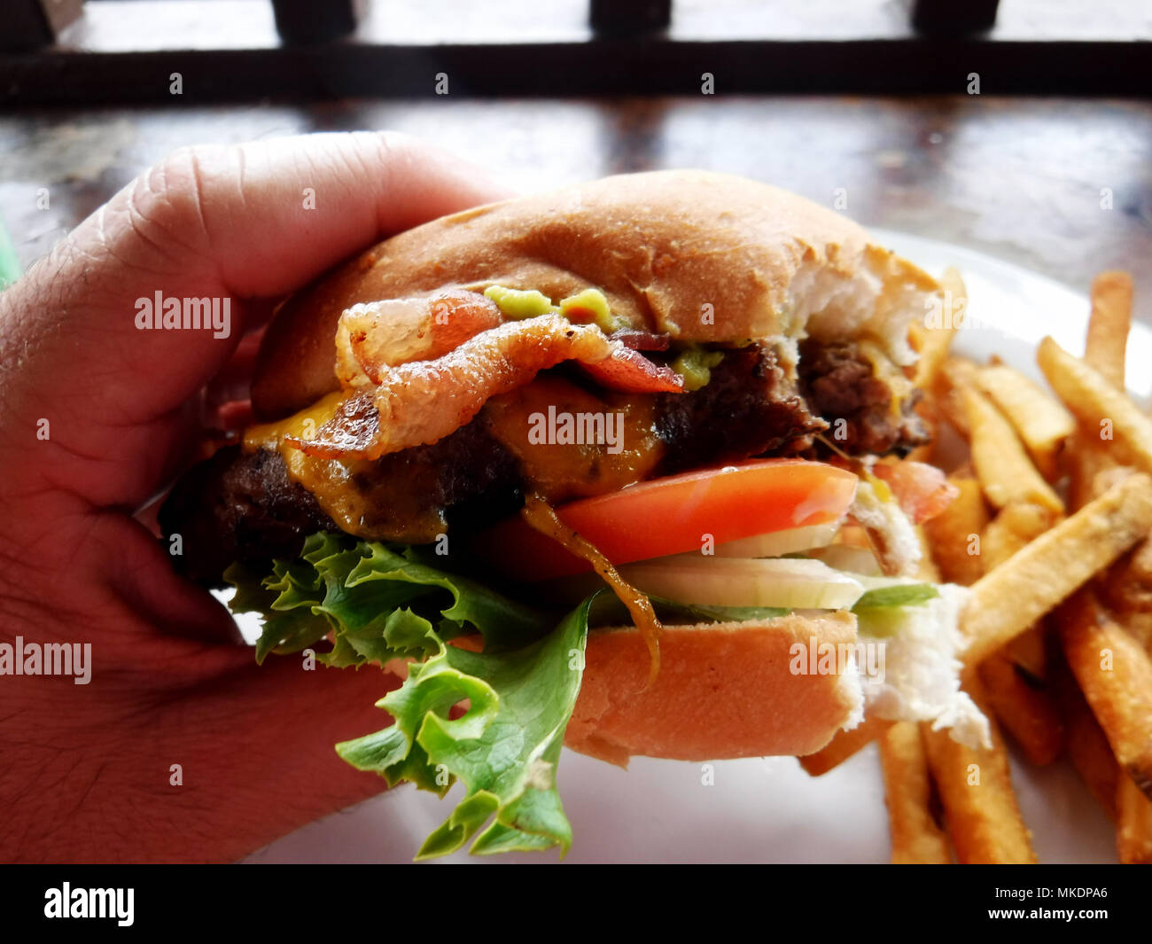 Aliments malsains. Cheese burger et frites dans un petit pain avec du bacon Banque D'Images