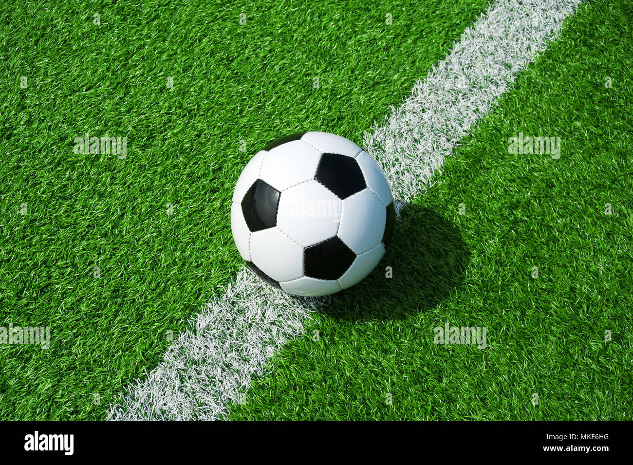 Ballon de football classique noir et blanc avec la ligne verte sur le