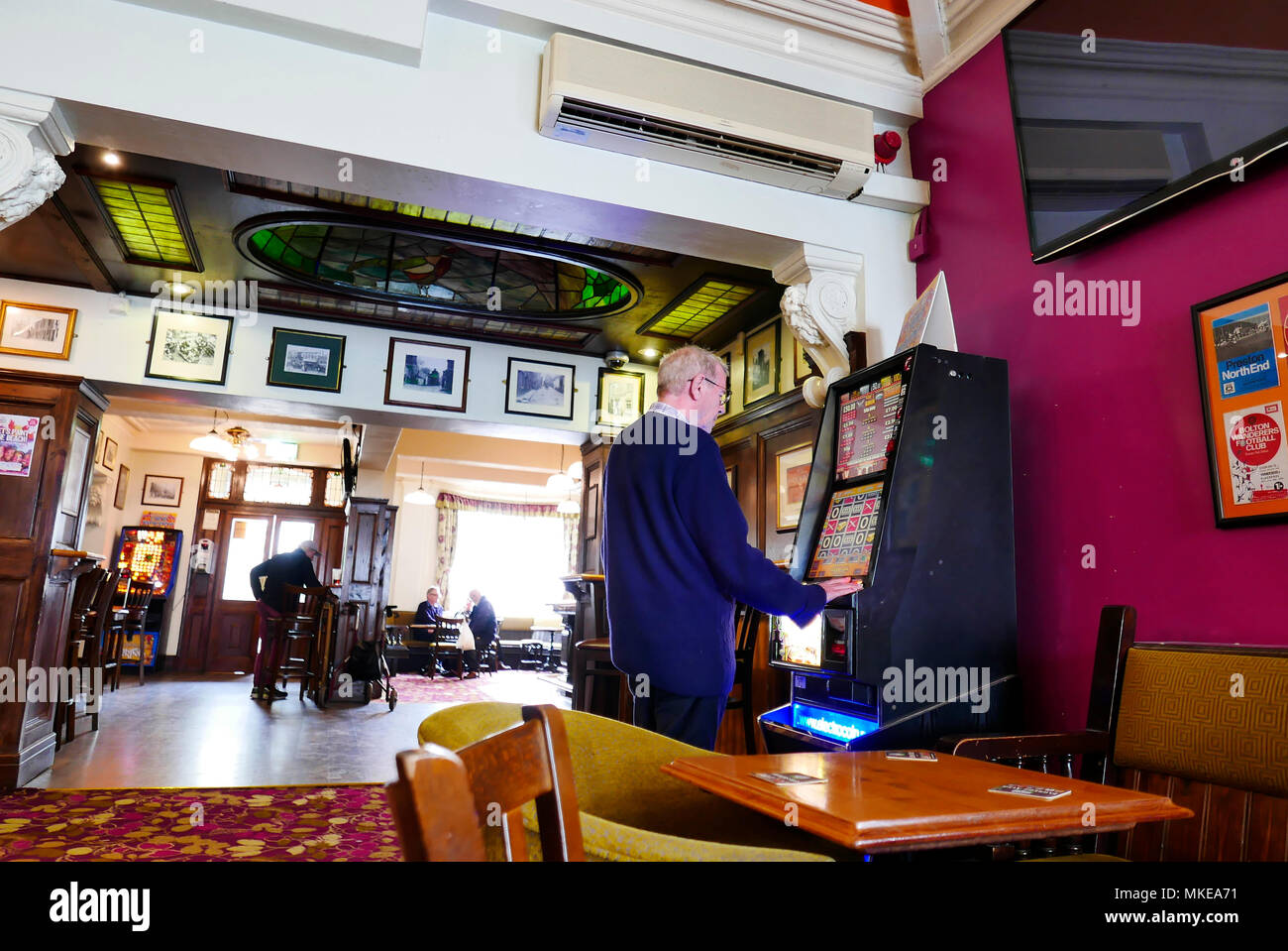 L'homme jouant sur la machine de jeu en public house Banque D'Images