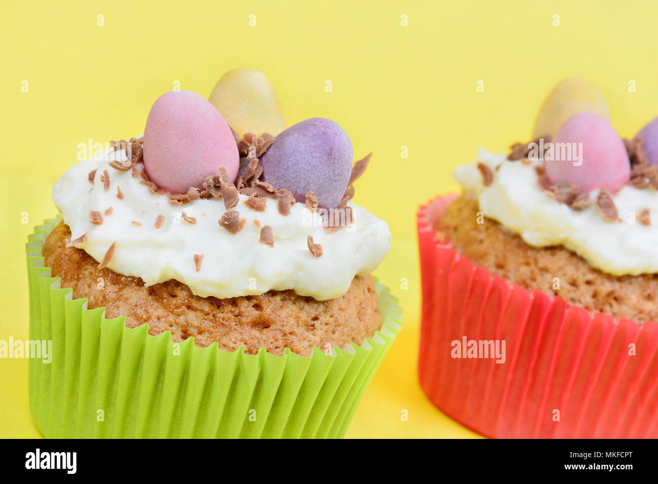 Close up of cupcakes avec des œufs en chocolat sur fond jaune Banque D'Images