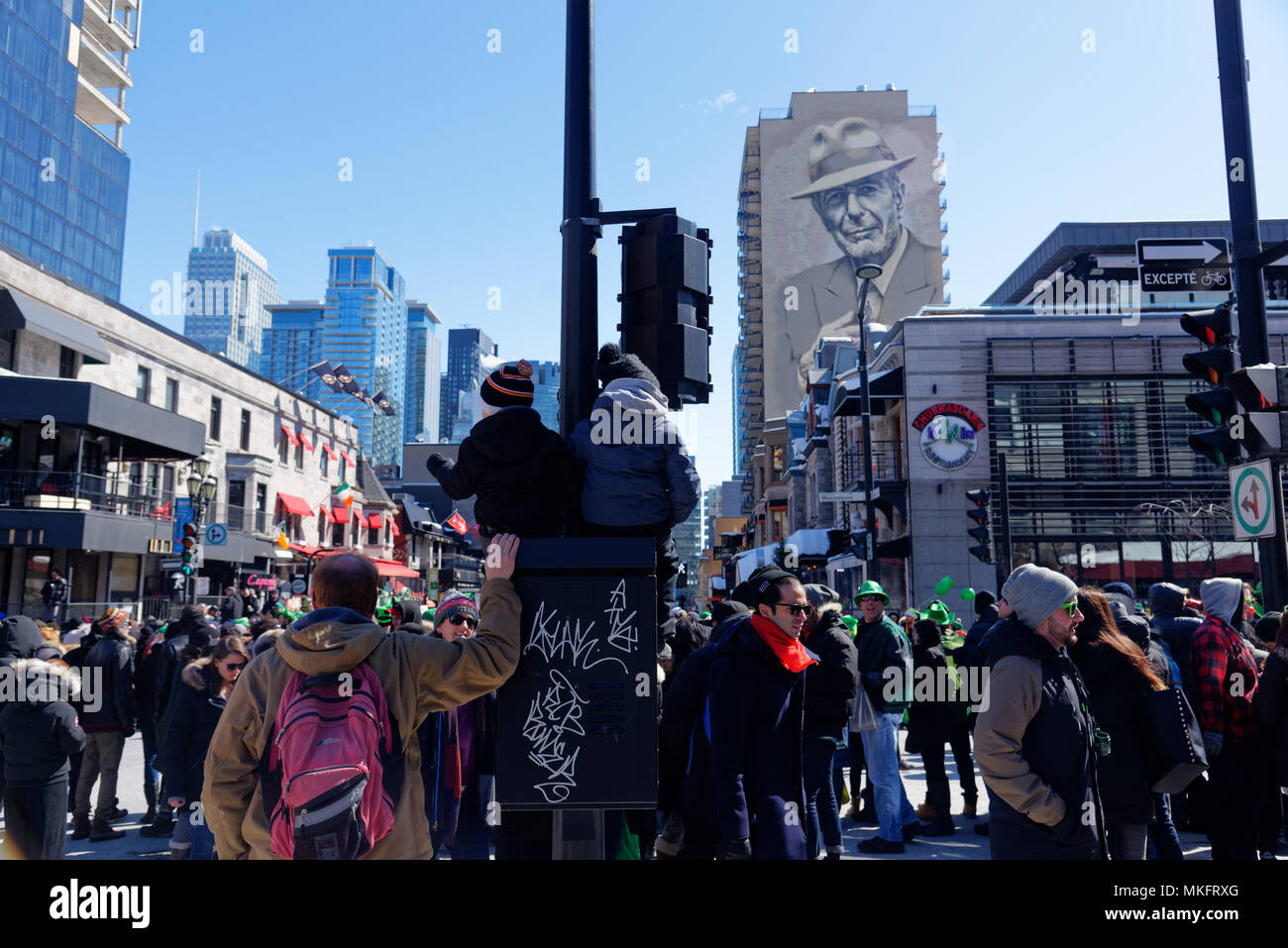 Deux enfants assis en hauteur pour regarder la parade de la St Patrick à Montréal Banque D'Images