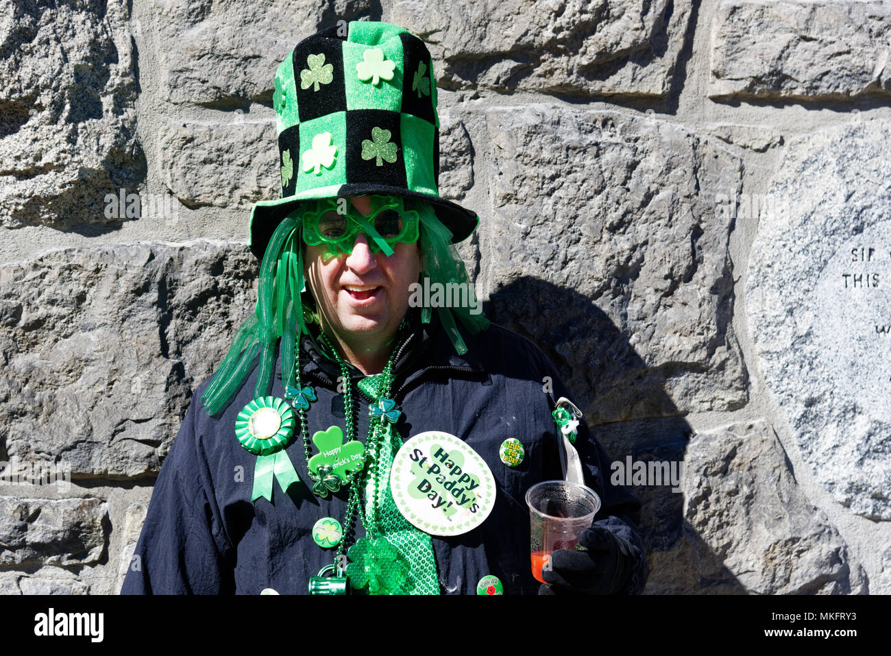 Un homme portant un chapeau vert et des lunettes à la parade de la St Patrick Banque D'Images