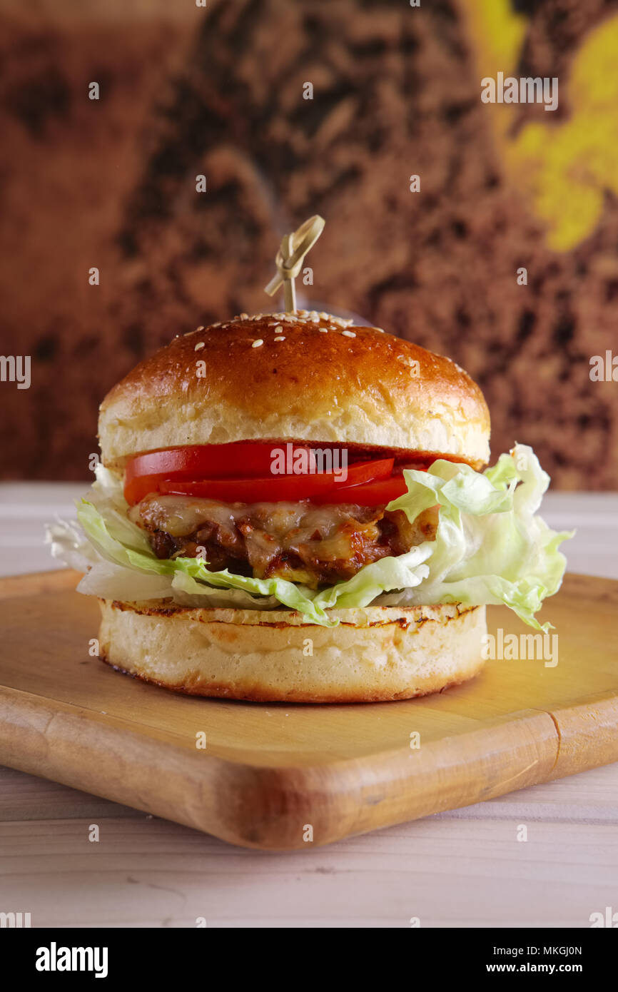 Bacon burger sur plaque de bois Banque D'Images