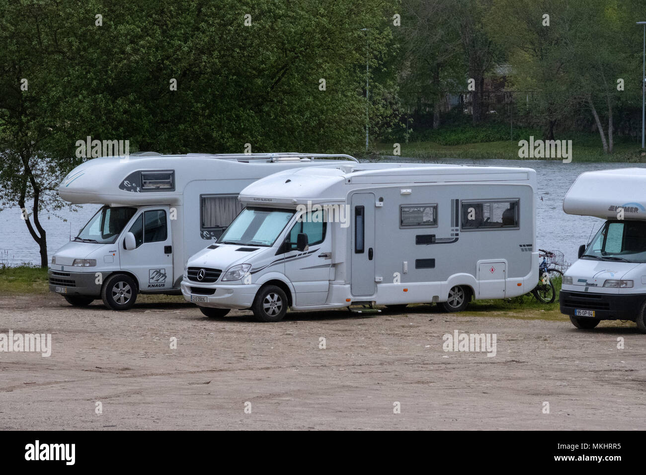 Trois camping-car garé à côté d'une rivière et de la forêt Banque D'Images