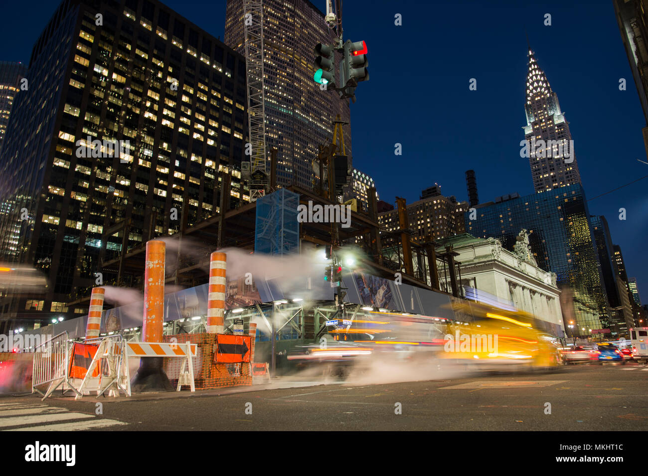 NEW YORK - Etats-Unis - 31 octobre 2017 - Une longue exposition photo de voitures traversant une intersection à New York pendant que la vapeur qui sort du trou. Banque D'Images