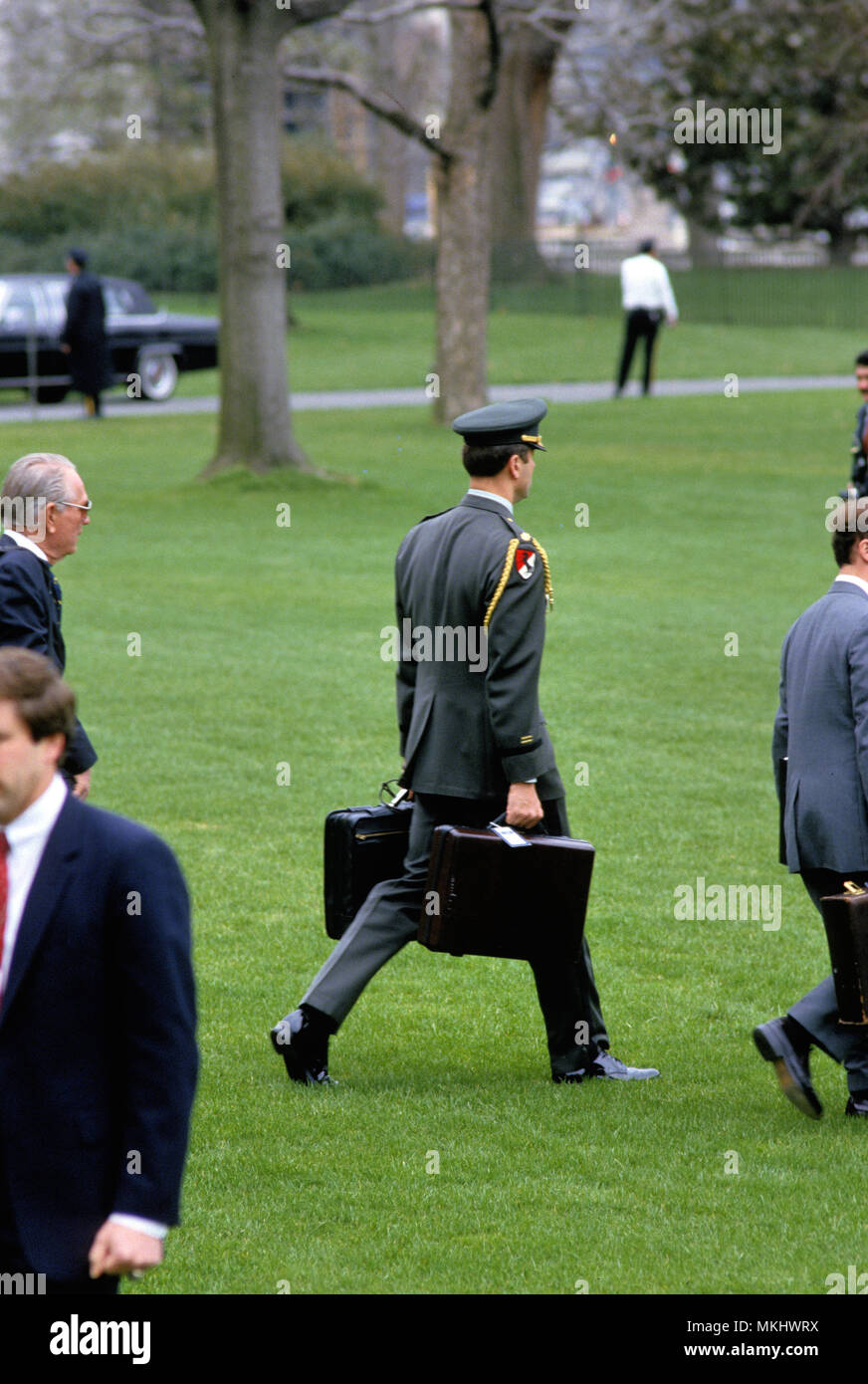 Washington, DC, USA, 1986. L'aide militaire transportant le "sac noir' avec la guerre nucléaire s'approche d'un marin des codes sur la pelouse Sud de la Maison Blanche : Marque de crédit/MediaPunch Reinstein Banque D'Images