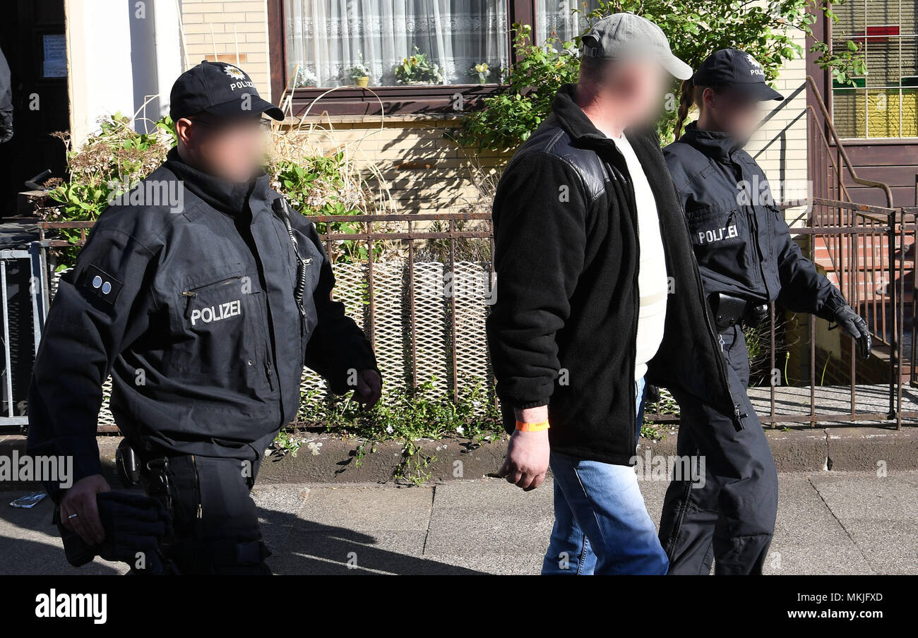 08 mai 2018, l'Allemagne, Bremen : policiers accompagner un homme placé dans une chambre d'une voiture de patrouille. La police allemande a lancé une grande opération de contrebande anti-peuple avec 800 officiers de police participant à des raids en appartements et bureaux dans le Nord et le centre de l'Allemagne. La raison pour les raids est la suspicion et commerciale fondée sur les gangs de la traite des étrangers. Photo : Carmen Jaspersen/DPA - ATTENTION : personne(s) a/ont été pixelisées pour des raisons juridiques Banque D'Images