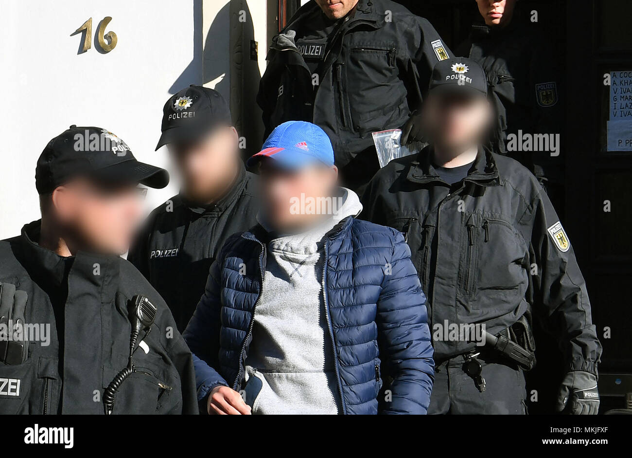 08 mai 2018, l'Allemagne, Bremen : policiers accompagner un homme placé dans une chambre d'une voiture de patrouille. La police allemande a lancé une grande opération de contrebande anti-peuple avec 800 officiers de police participant à des raids en appartements et bureaux dans le Nord et le centre de l'Allemagne. La raison pour les raids est la suspicion et commerciale fondée sur les gangs de la traite des étrangers. Photo : Carmen Jaspersen/DPA - ATTENTION : personne(s) a/ont été pixelisées pour des raisons juridiques Banque D'Images