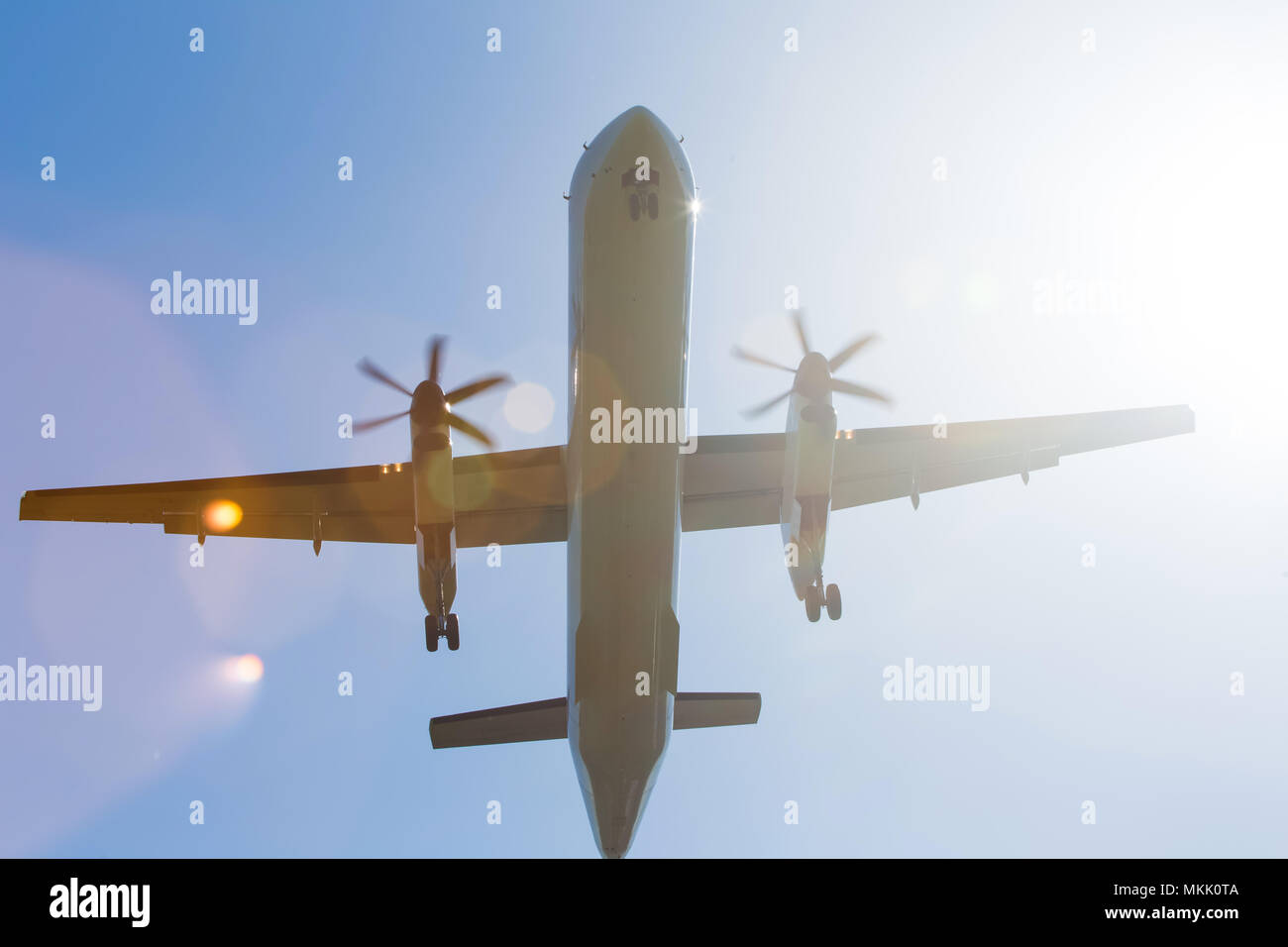 Avion à turbopropulseur dans le ciel par le dessous avec les rayons du soleil Banque D'Images