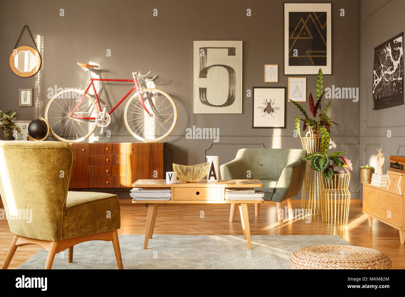 Table en bois et un fauteuil vert sur tapis gris en vintage salon intérieur avec vélo rouge sur l'armoire Banque D'Images