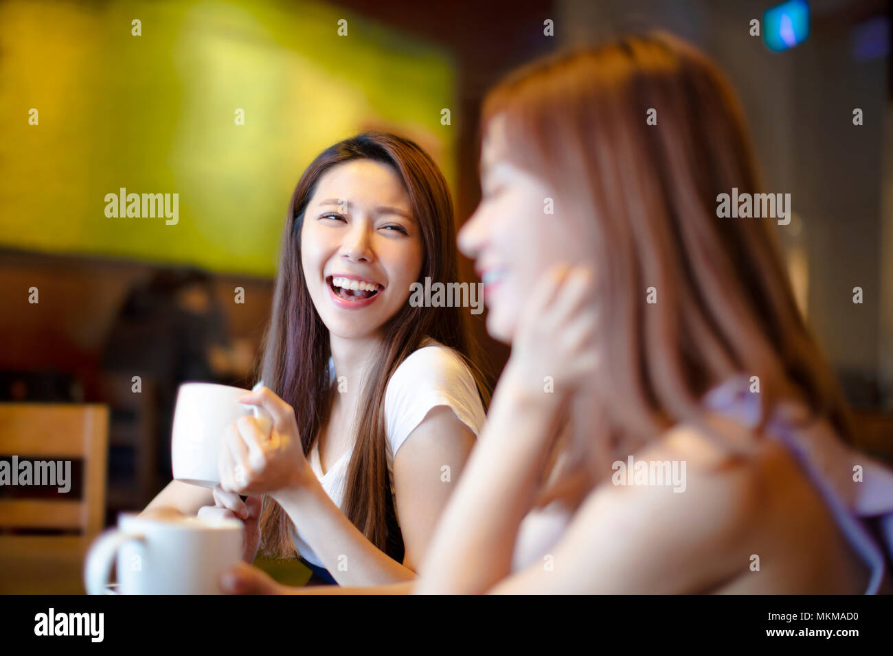 Deux jeunes laughing women in coffee shop Banque D'Images