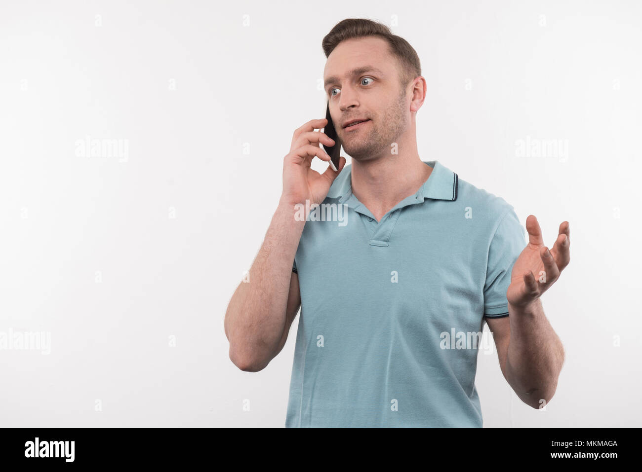 L'homme émotionnel beau parler au téléphone Banque D'Images