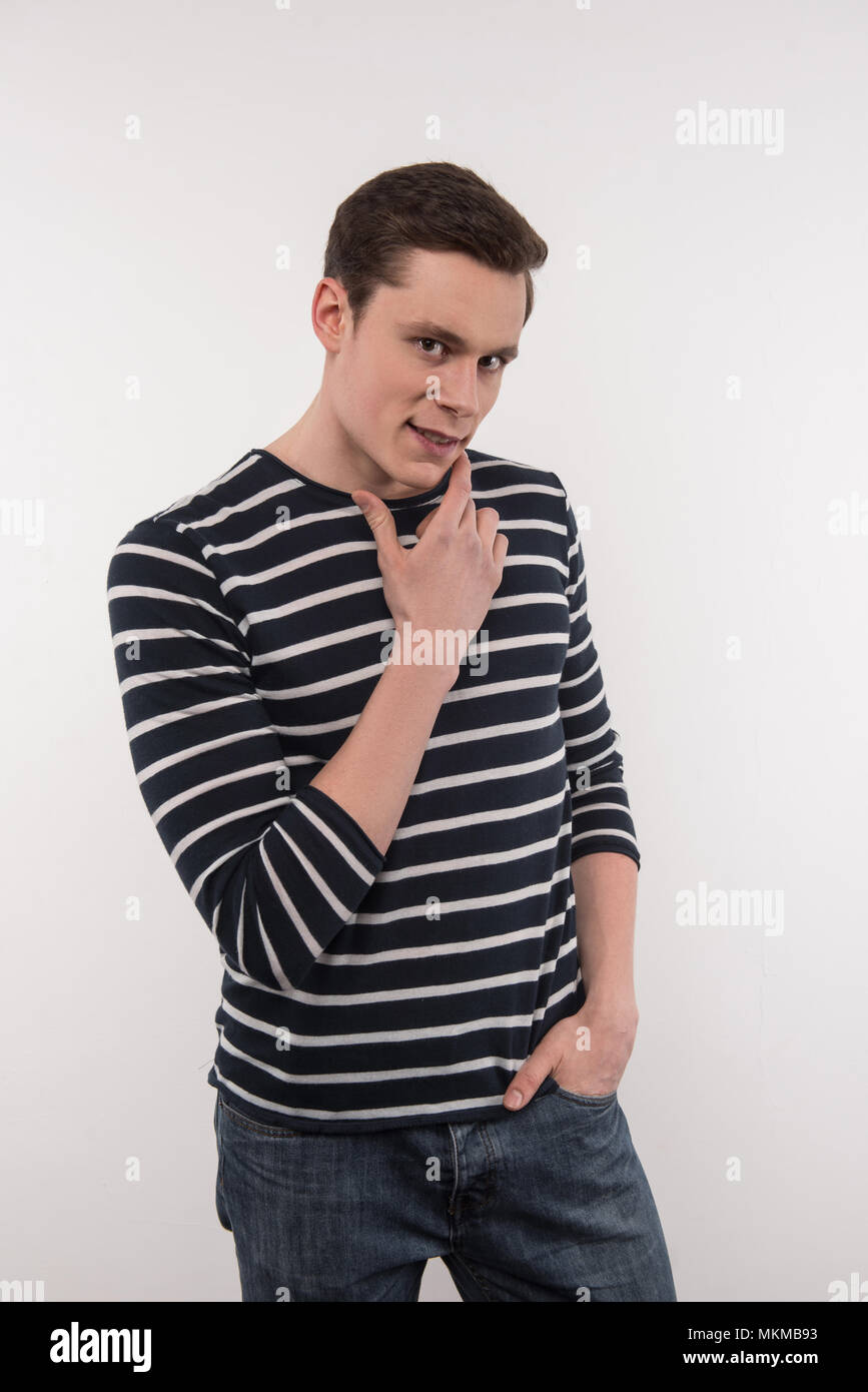 Cheerful man positive de toucher son menton Banque D'Images