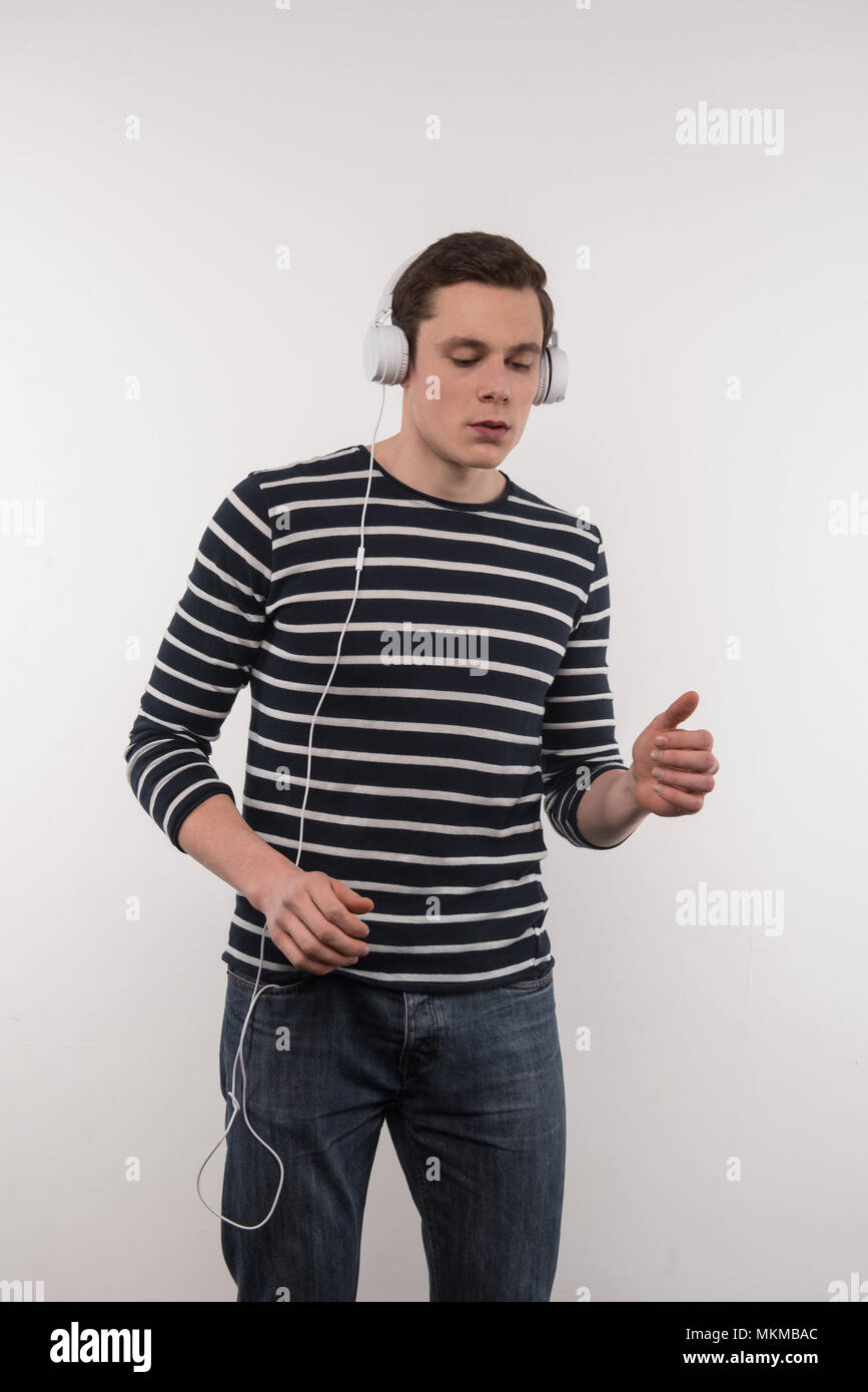 Jeune homme agréable à écouter de la musique Banque D'Images
