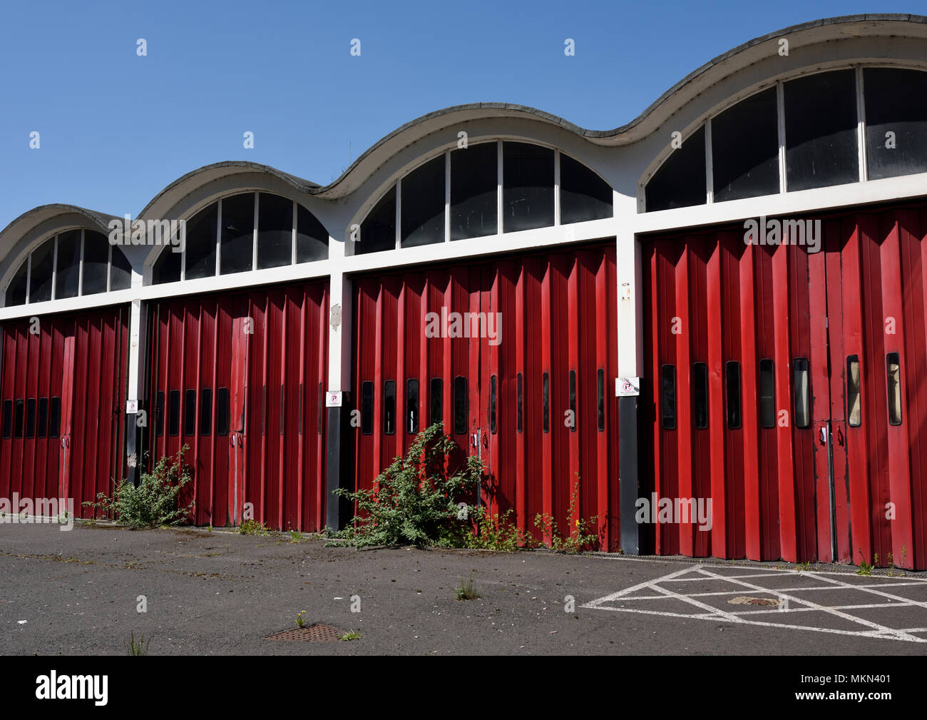 Portes pliantes en accordéon rouge et toit curviligne avec vitres en verre sur la caserne de pompiers désutilisée de bury lancashire au royaume-uni Banque D'Images