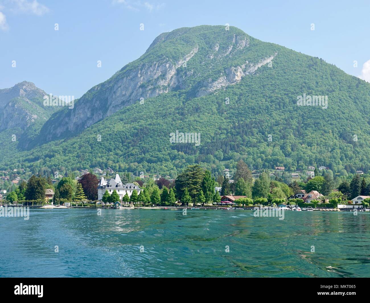 Vue sur le paysage de montagne au-delà des rives du lac d'Annecy à Menton-Saint-Bernard, France. Banque D'Images