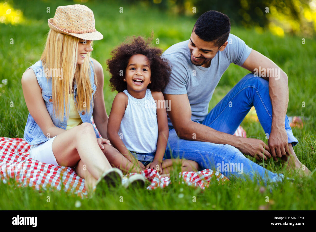 Photo de jolie couple avec leur fille having picnic Banque D'Images