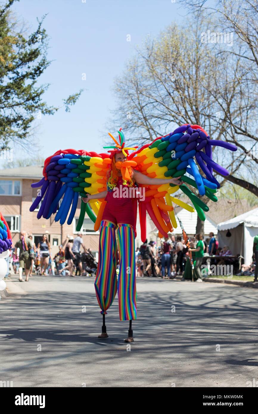 Une personne sur des échasses habillé comme un papillon arc-en-ciel de ballons au défilé du jour de mai et festival à Minneapolis, Minnesota, USA. Banque D'Images