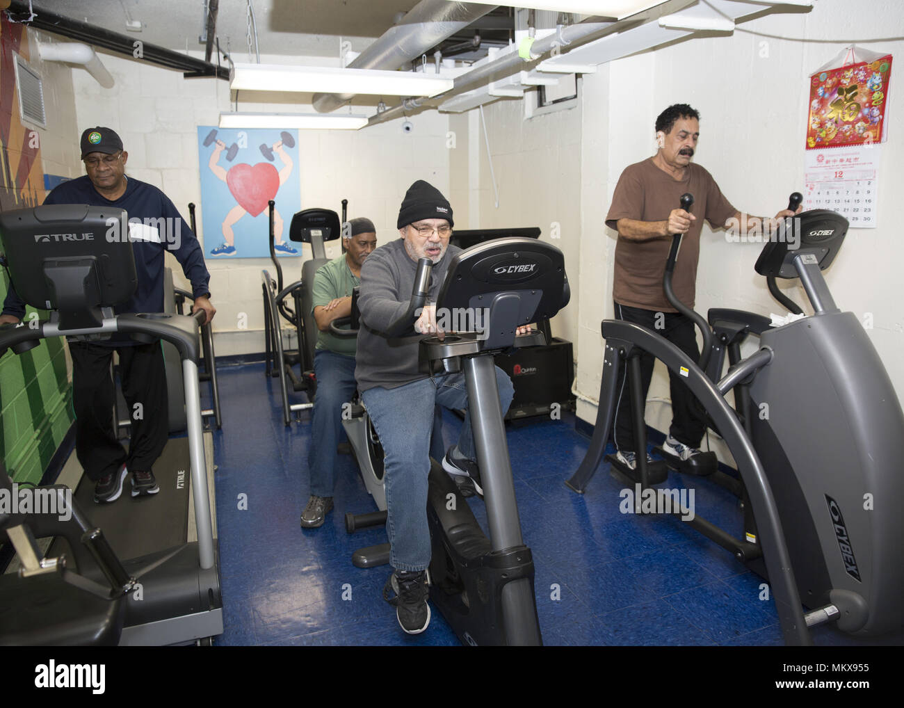 Les hommes de se tenir en forme, travaillant sur la machines d'exercice fournis à un centre principal régulateur sur Lower East Side, Manhattan, New York City. Banque D'Images