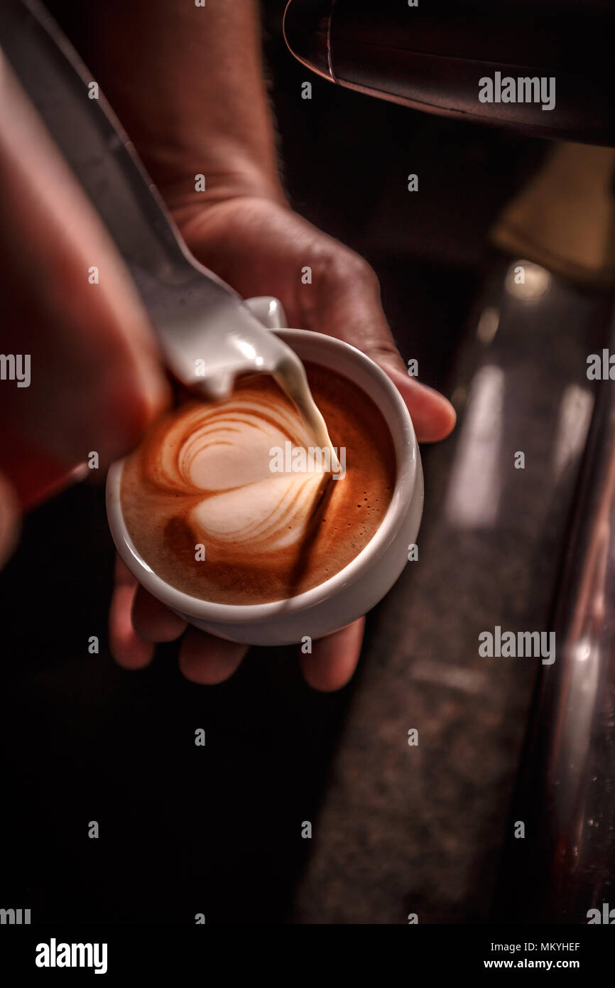 Barista pouring lait pour préparer tasse de café, café latte art, préparation et service concept Banque D'Images