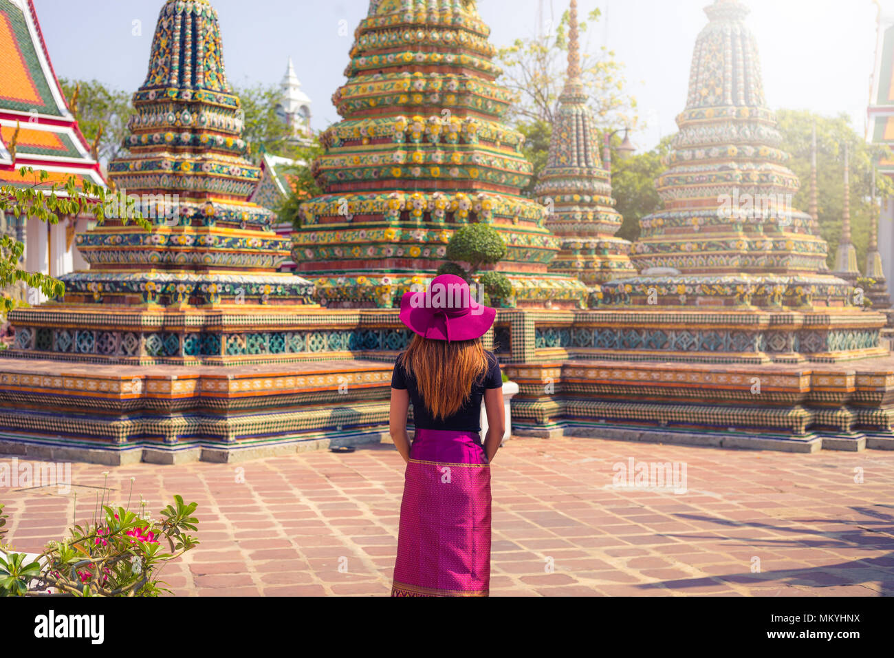 Les femmes thaïlandaises avec des vêtements traditionnels en permanent avant de stuppas en temple de Wat Pho à Bangkok en jour , Thaïlande Banque D'Images