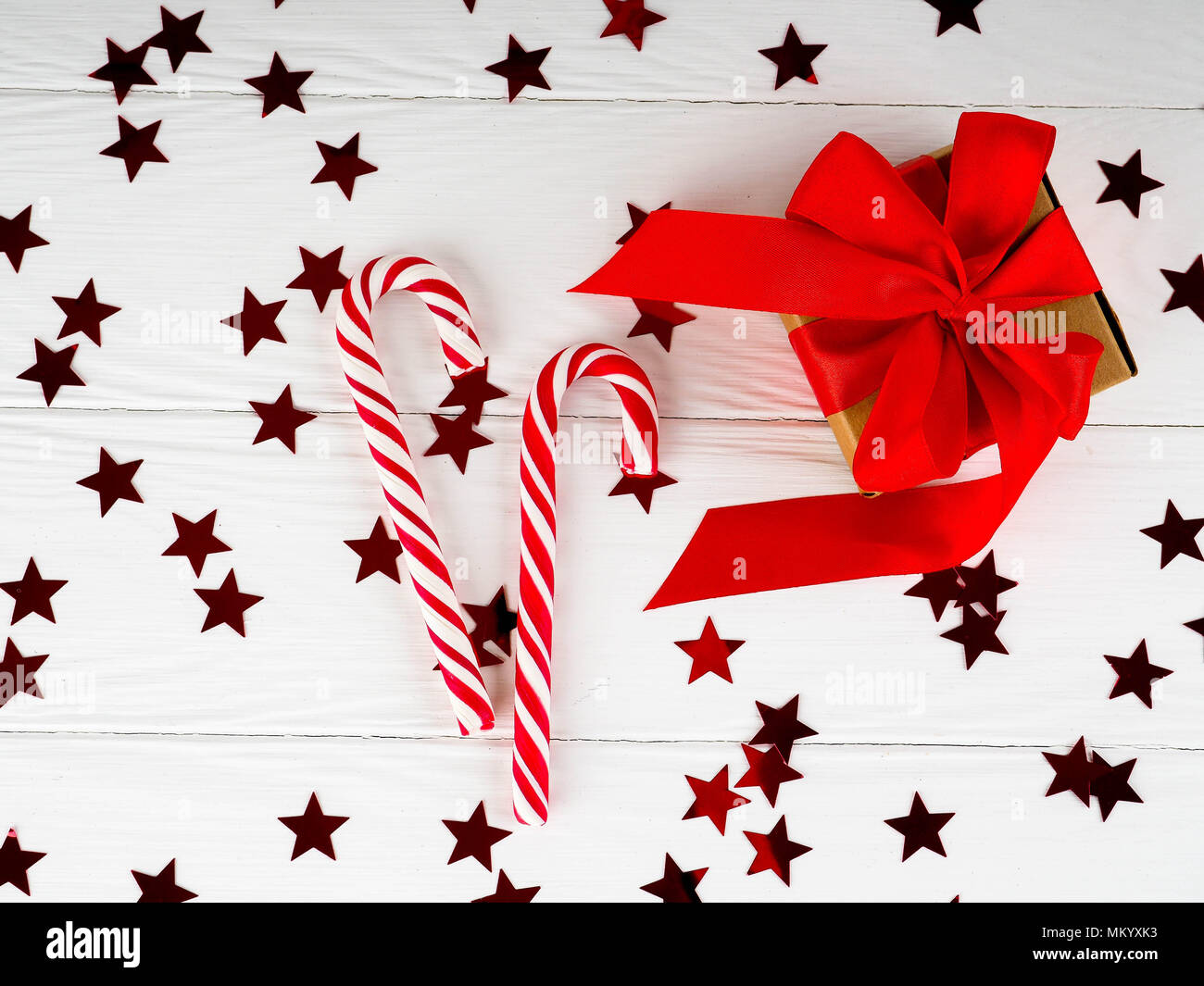 Canne de Noël sur fond de bois blanc, décors de Noël cadeaux rouge. Banque D'Images