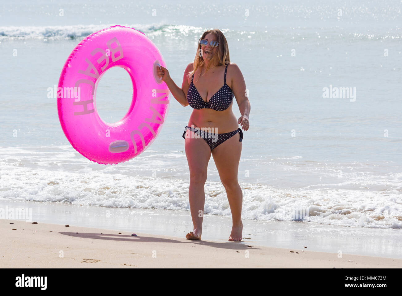 Bournemouth, Dorset, UK. Le 9 mai 2018. Météo France : le soleil brille toujours ! Un autre ensoleillé chaud pour commencer la journée, en tant que visiteurs, chef de la plage avant le temps change. Sophia de Birmingham est en compagnie de ses vacances chez soi par la mer à Bournemouth, elle est titulaire d'un anneau en caoutchouc gonflable rose au bord de la mer. Credit : Carolyn Jenkins/Alamy Live News Banque D'Images