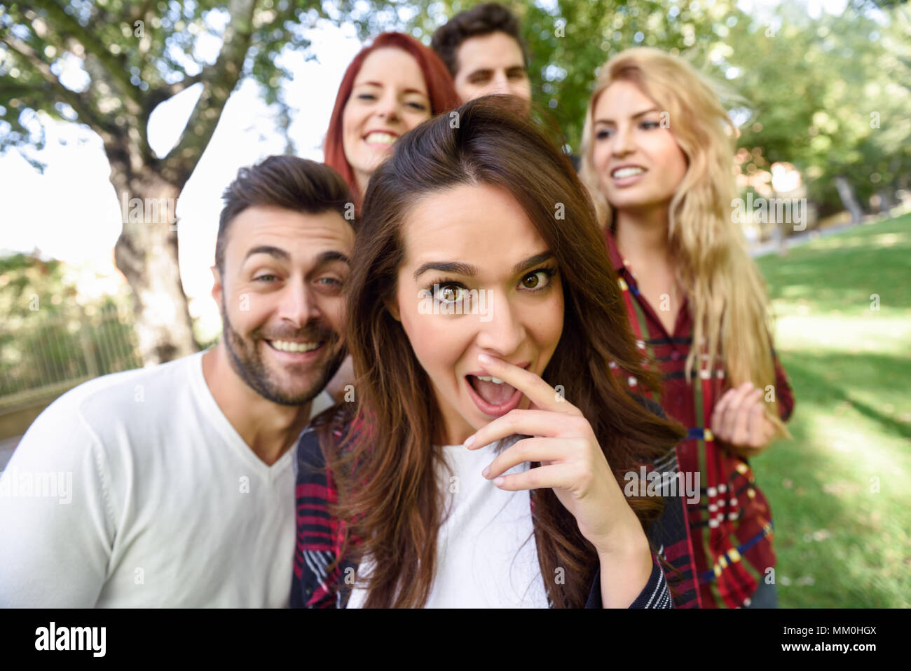 Groupe d'amis prenant en selfies. fond urbain Cinq jeunes gens portant des vêtements décontractés. Banque D'Images