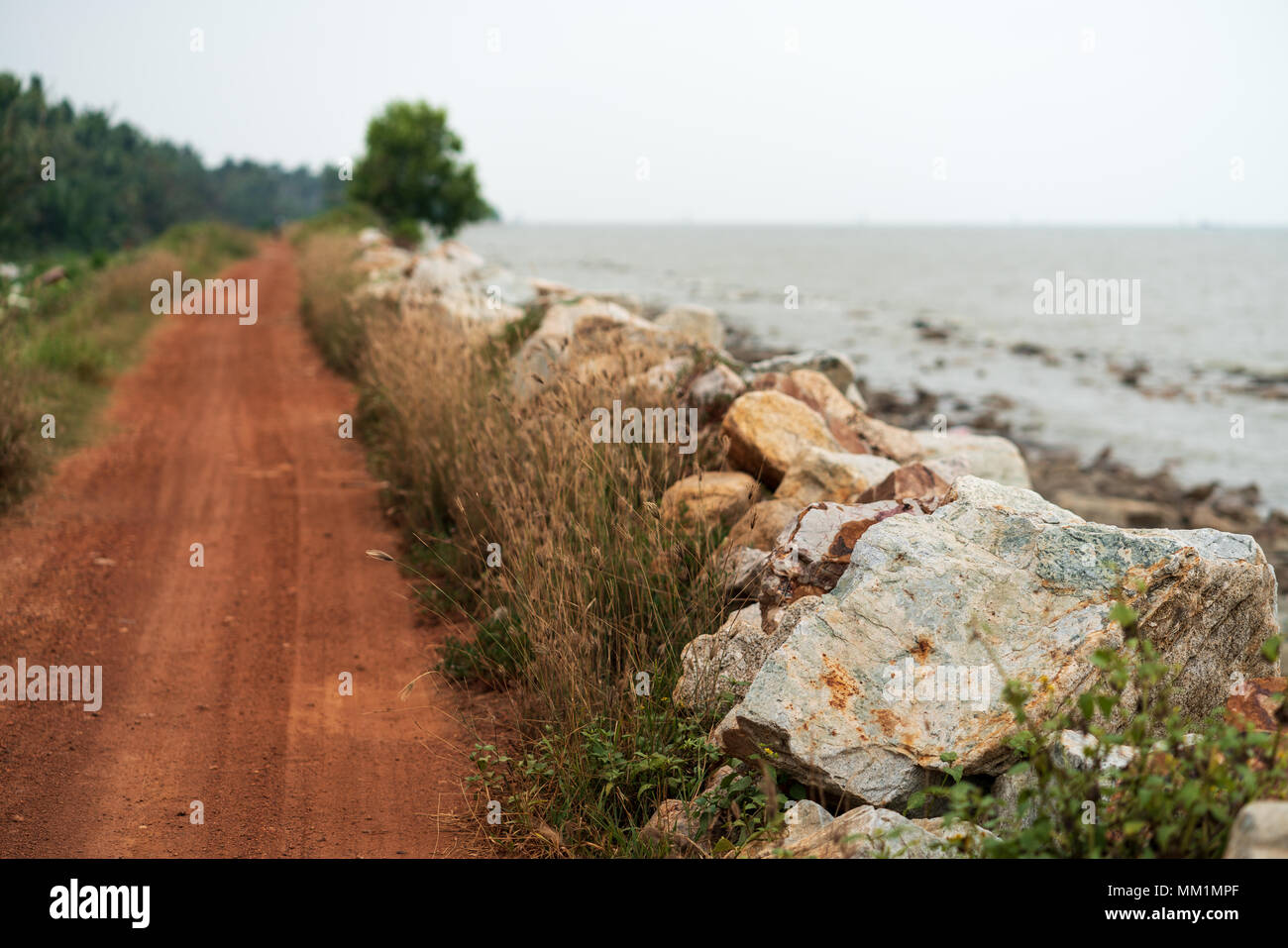 Chemin de terre à côté de la côte de la mer de rochers situé près de la plage à Sekinchan, Selangor, Malaisie. Banque D'Images