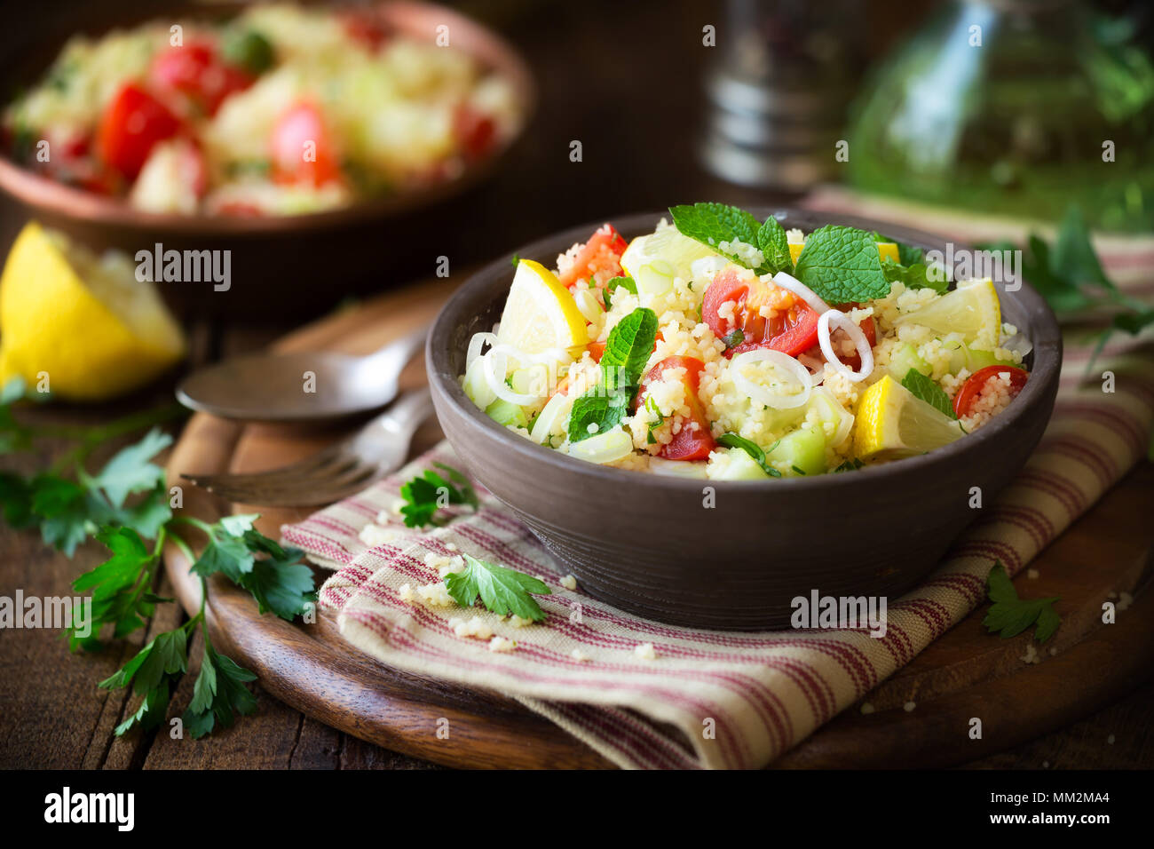 Taboulé - Végétarien salade de couscous délicieux avec des tomates cerises, concombres, menthe fraîche et les feuilles de persil. Banque D'Images