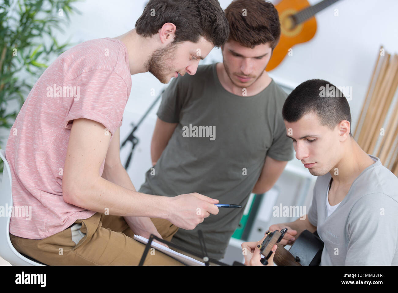 Les jeunes hommes la composition musicale l'un jouer de la guitare Banque D'Images