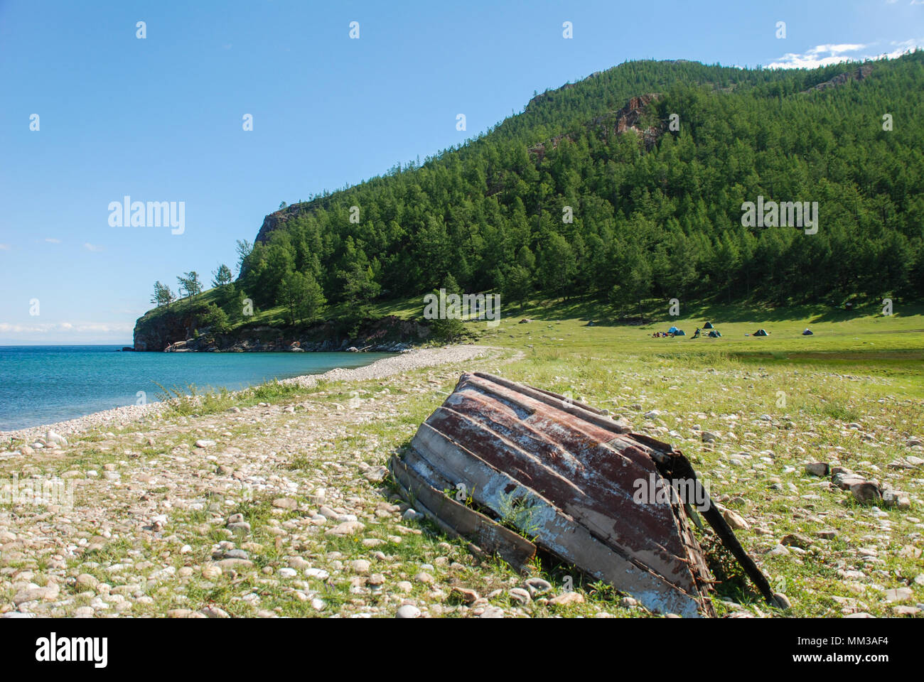 Ancien bateau de pêche à l'envers sur le bord d'un lac de montagne Banque D'Images