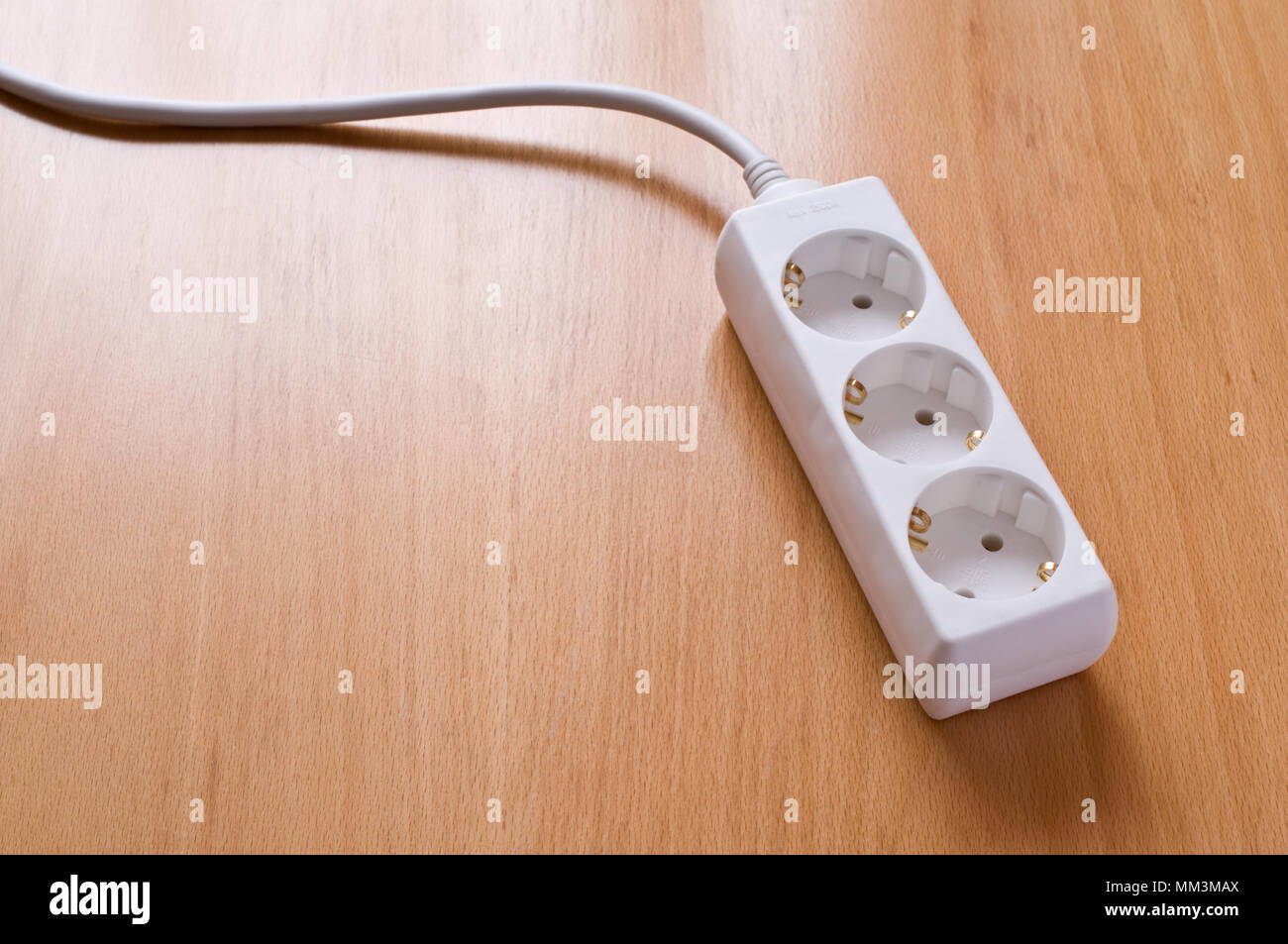 Prise de courant multiples sur un plancher en bois. Banque D'Images