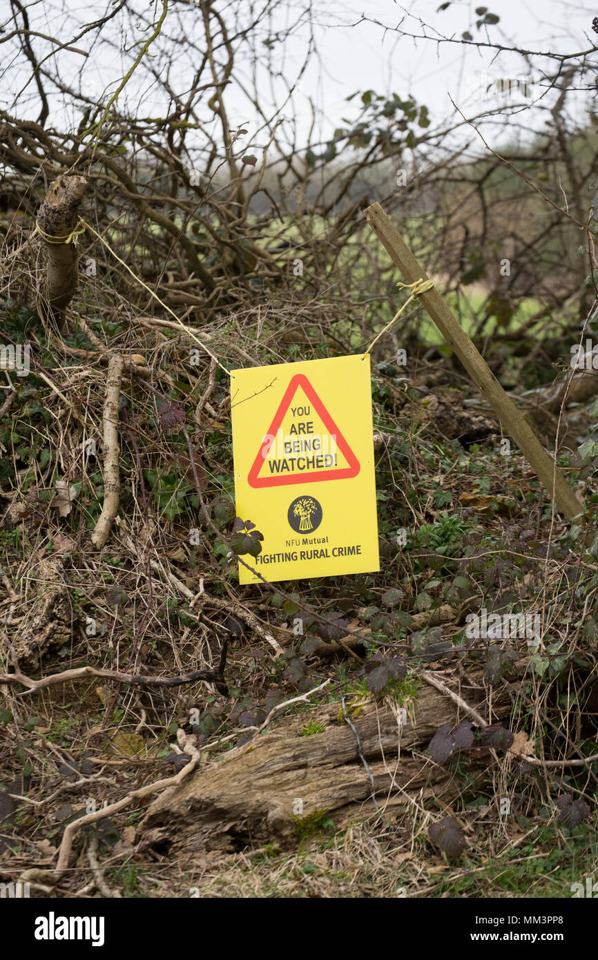 Un panneau d'avertissement aux côtés de terres agricoles visant à prévenir la criminalité dans les zones rurales. Nord du Dorset England UK. Banque D'Images