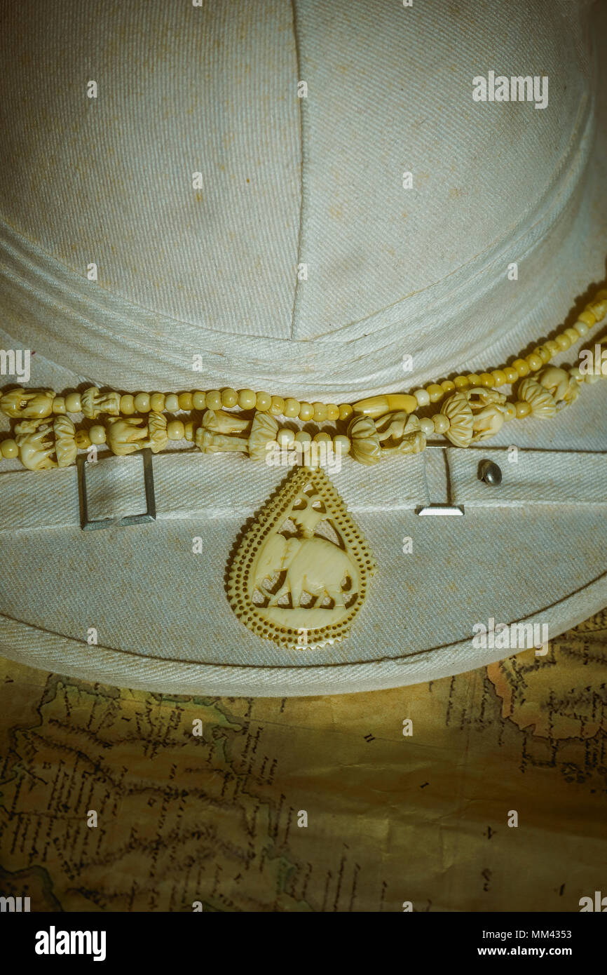 Collier d'ivoire d'éléphants sur vintage casque colonial sur des cartes Banque D'Images