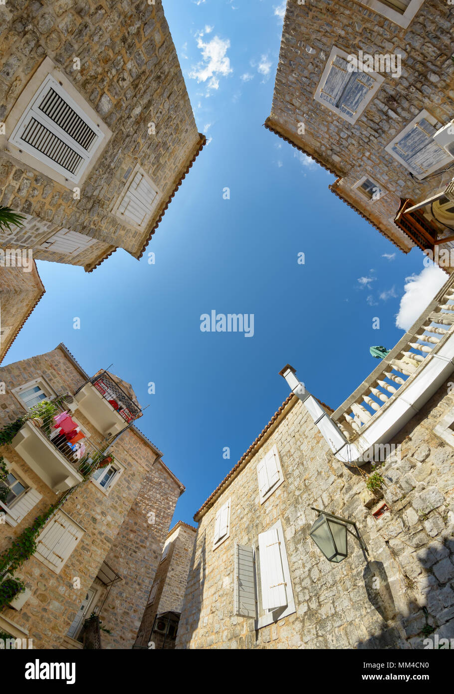 Petite place pittoresque avec des maisons en pierre de la vieille ville de Budva, grand angle vue de bas en haut avec ciel bleu, l'Europe des Balkans Monténégro Banque D'Images